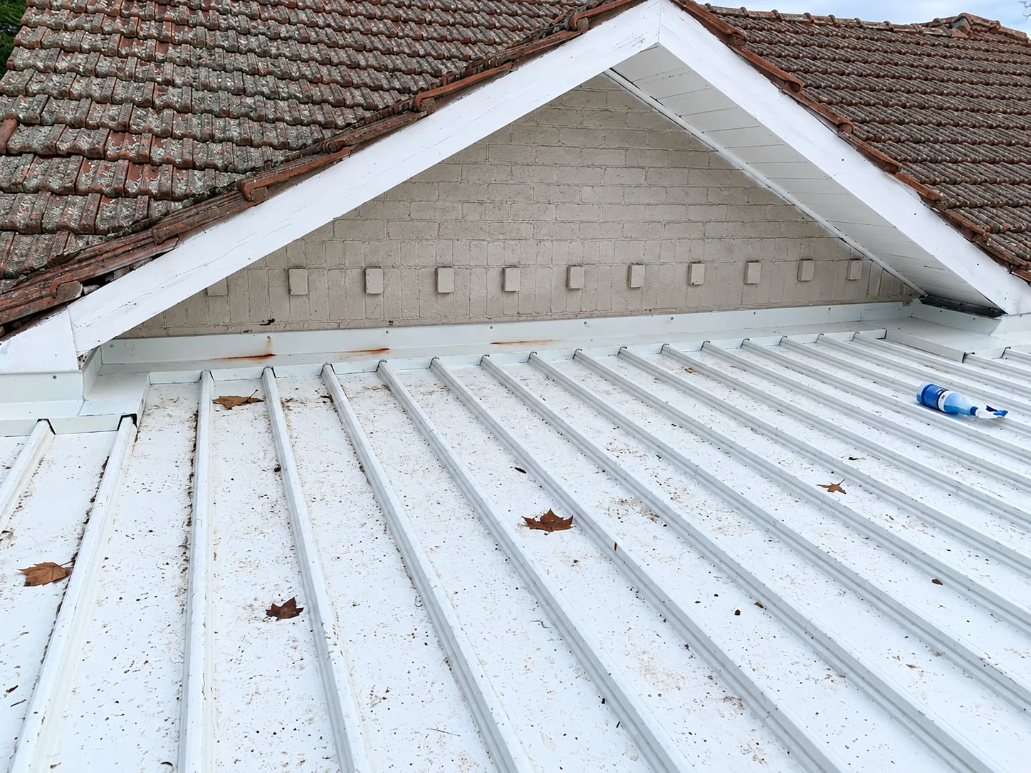 Roof edge and drainage detail on a tiled-roof property.